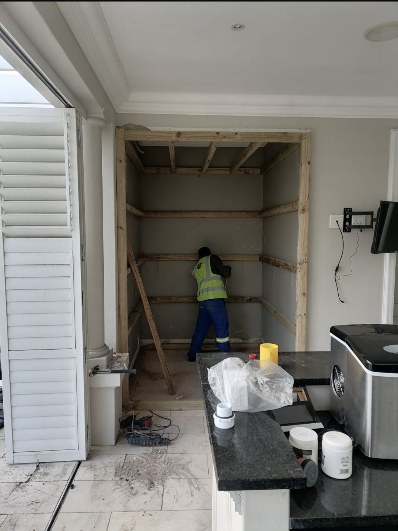 Technician installing timber framing inside a wall alcove