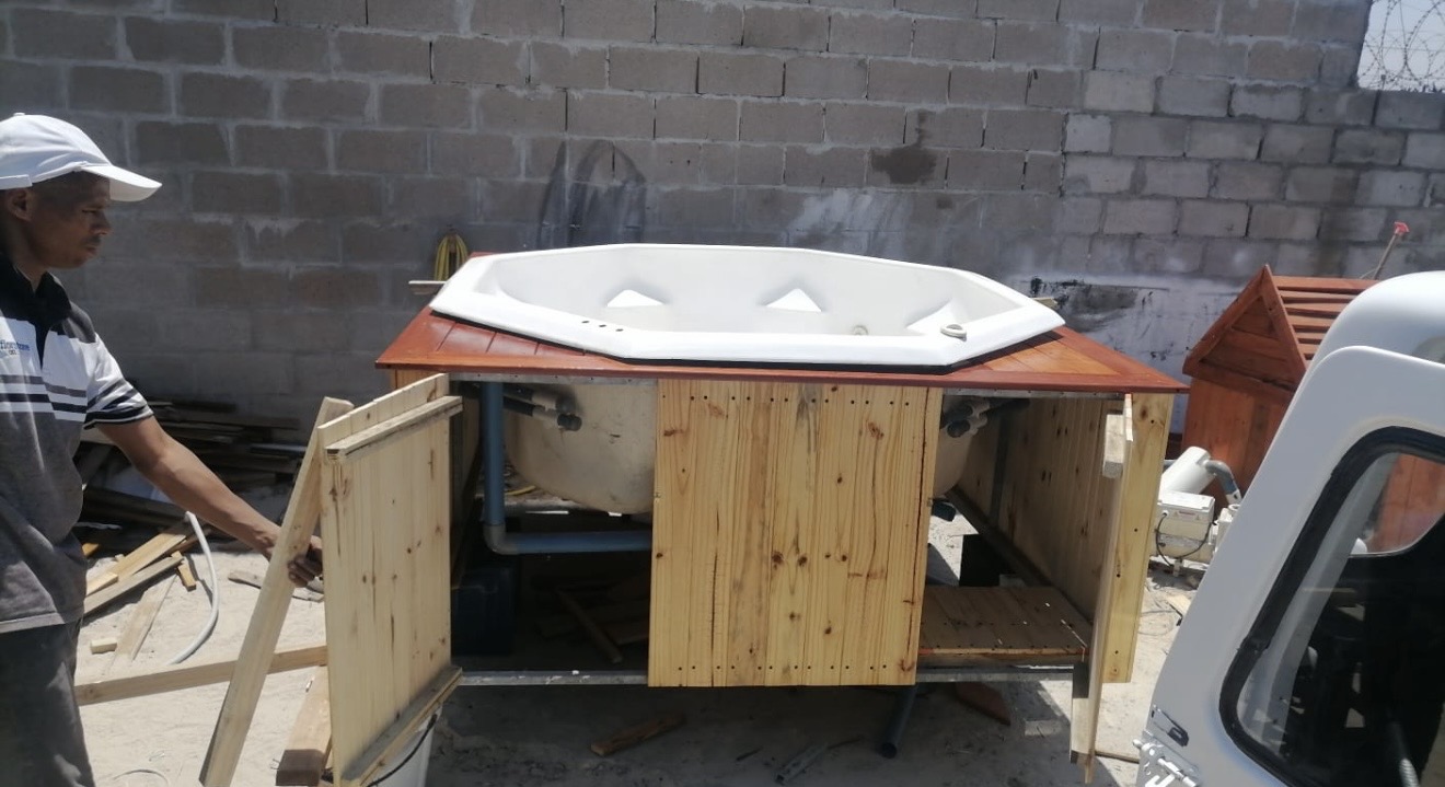 Jacuzzi shell being clad with pine panels in the workshop